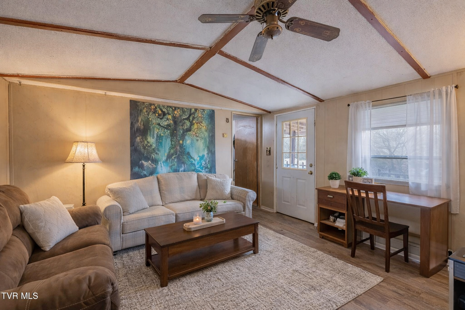 Living room with vaulted ceiling and front entry